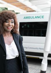 A woman standing in front of an ambulance